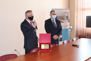 Sala konferencyjna Wojewoda Świętokrzyskie ubrany w garnitur koloru czarnego składa podziękowania Dyrektorowi Szpitala w czerowej Górze ubranegfo w garnitur koloru czarnego.
