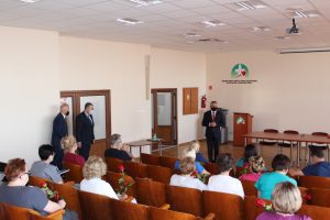 Sala konferencyjna przemawia Wojewoda Swiętokrzyski ubrany w garnitur koloru czarnego oraz w maseczce ochronnej kolori=u czarnego na twarzy w asyscie Dyrektora Szpitala.