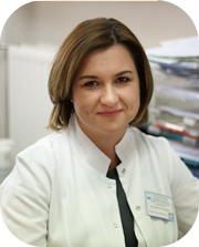 kobieta ubrana w białą odzież ochronną usmiecha się