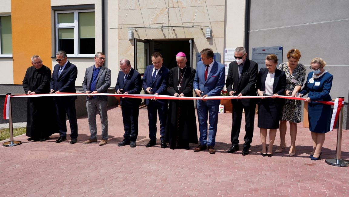 osoby ubrane w ubrania medyczne i wizytowe oraz maseczki ochronne na twarzy podczas przecięcia stęgi biało czerwonej otwarcia oddziału ZOL szpitala.