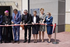 osoby ubrane w ubrania medyczne i wizytowe oraz maseczki ochronne na twarzy podczas przecięcia stęgi biało czerwonej otwarcia oddziału ZOL szpitala.
