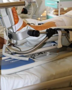 stopa ludzka po zabiegu operacyjnym ortopedycznym w szynie usztywniającej koloru srebno czarnego