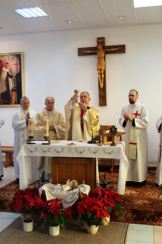 czterech księży ubranych w białe ubrania podczas mszy świętej w kaplicy szpitalnej