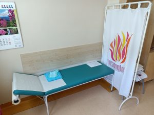 pomieszczenie poradni alergicznej wyposażone w leżak madr=yczny koloru niebieskiego obok biały parawan