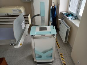 aparat rtg koloru szaro turkusowego wraz z łózkiem medycznym koloru szarego
