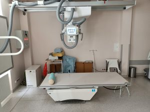 pracownia rtg wraz z aparatem do badaniań i białem łóżkiem do diagnostyki RTG