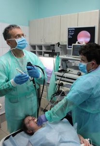 lekarz wykonujący badaniie gastroskopii wraz z pielęgniarka pacjentowi szpitala