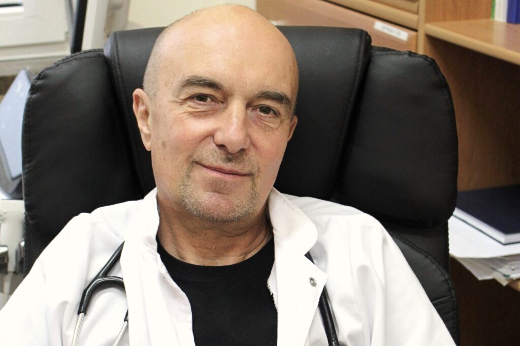 Profesor Pałczyński, lekarz, biały fartuch, na czarnym tle fotela, stetoskop na szyi