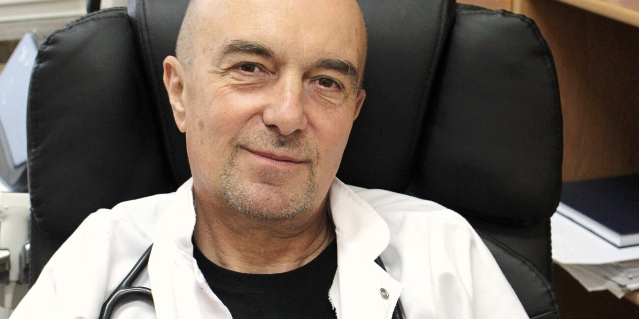 Profesor Pałczyński, lekarz, biały fartuch, na czarnym tle fotela, stetoskop na szyi