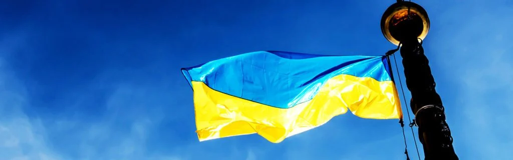 flaga Ukrainy powiewająca na wietrze na tle nieba.