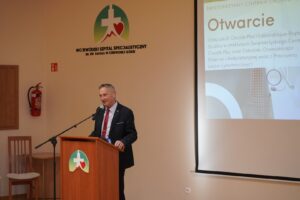 Fotografia przedstawia przemawiającego mężczyznę podczas prezentacji z otwarcia nowego oddziału