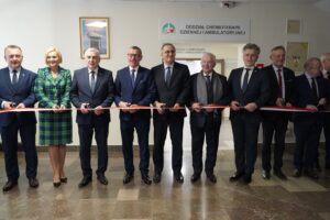 Grupa osób przecinająca wstęgę charakteryzującą otwarcie nowego oddziału