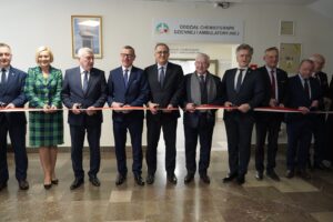 Grupa osób przecinająca wstęgę charakteryzującą otwarcie nowego oddziału