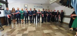 Grupa osób przecinająca wstęgę charakteryzującą otwarcie nowego oddziału