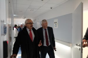 Dwóch Panów spacerujących po szpitalnym korytarzu