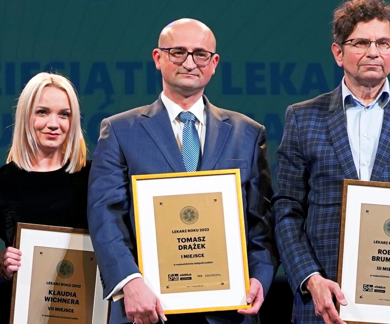 Laureaci plebiscytu "Lekarz Roku". Fotografia przedstawia trzech mężczyzn i jedną kobietę trzymających wyróżnienia.